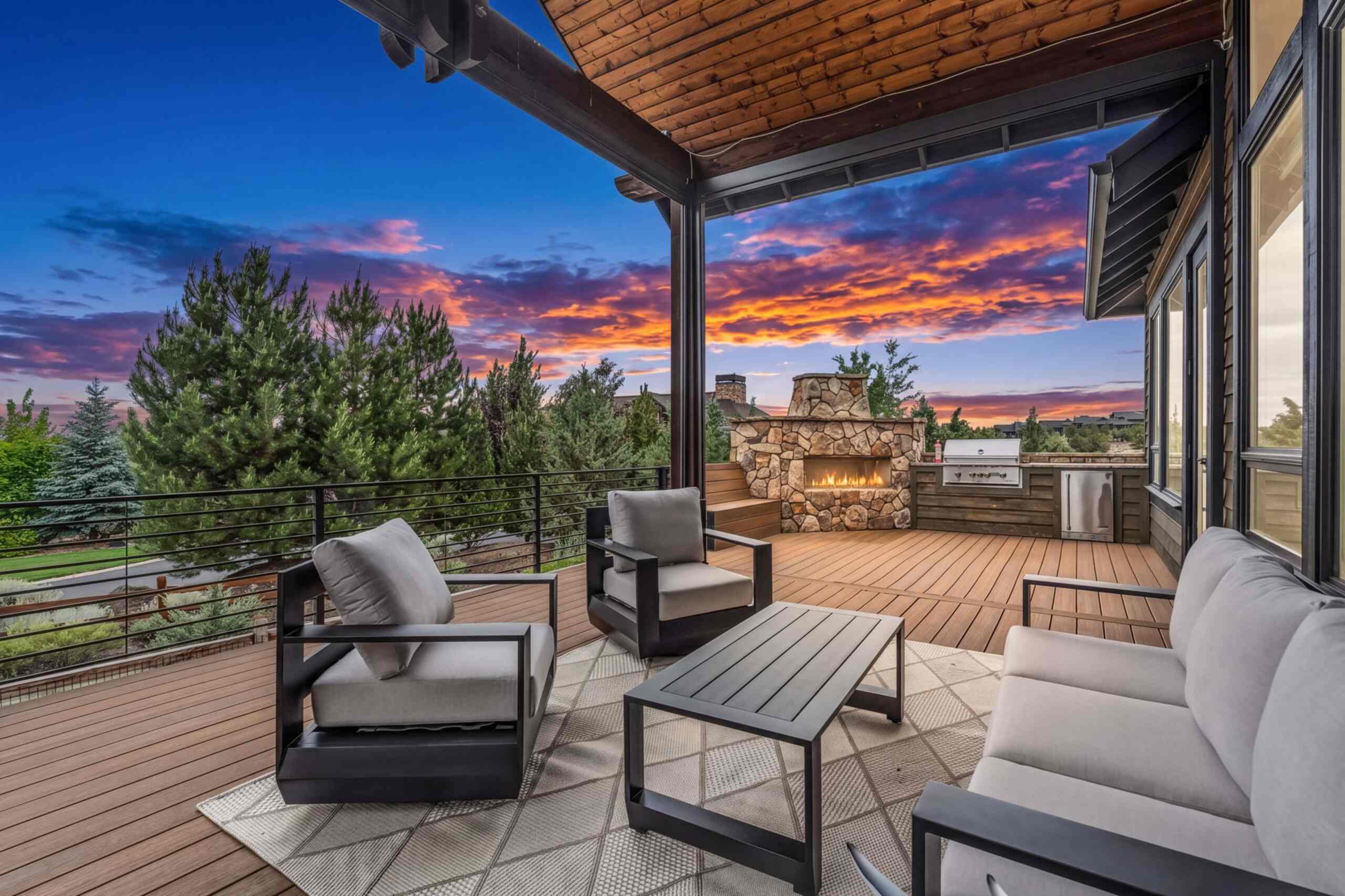Covered deck with outdoor seating and a sunset view at a Central Oregon vacation rental